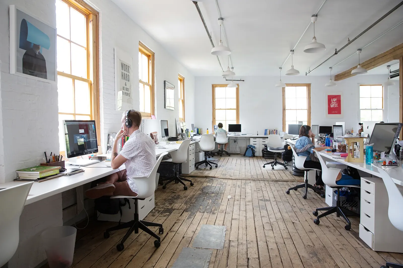 Team members working at computers in a bright open agency office