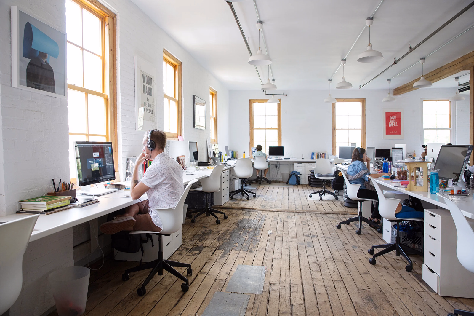 Team members working at computers in a bright open agency office