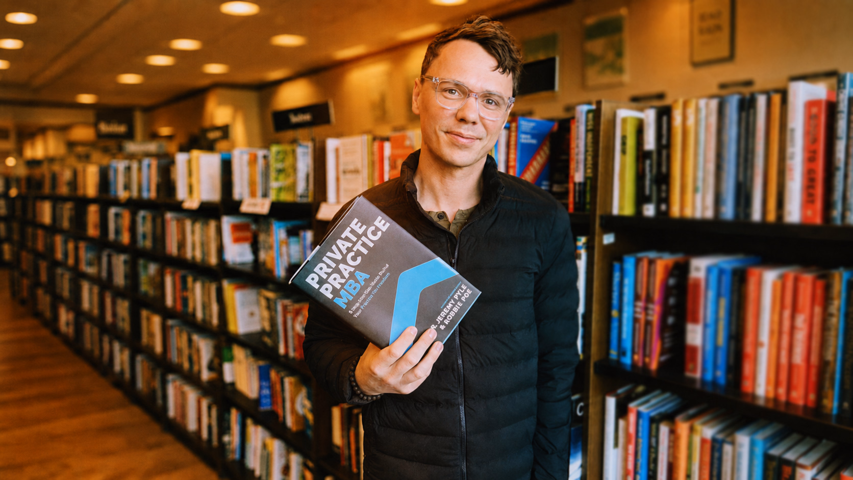 Robbie Poe holding Private Practice MBA in a bookstore