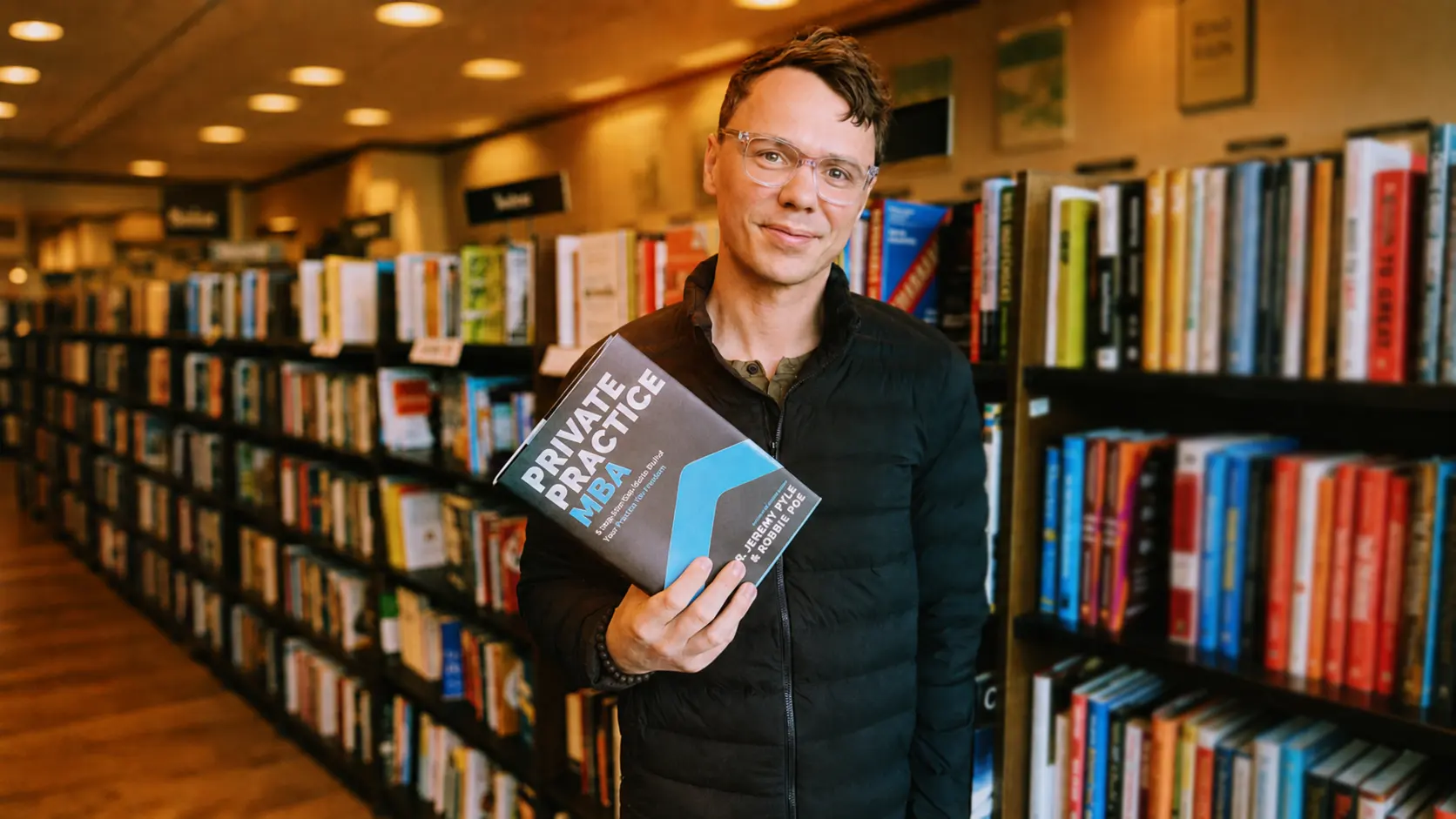 Robbie Poe holding Private Practice MBA in a bookstore