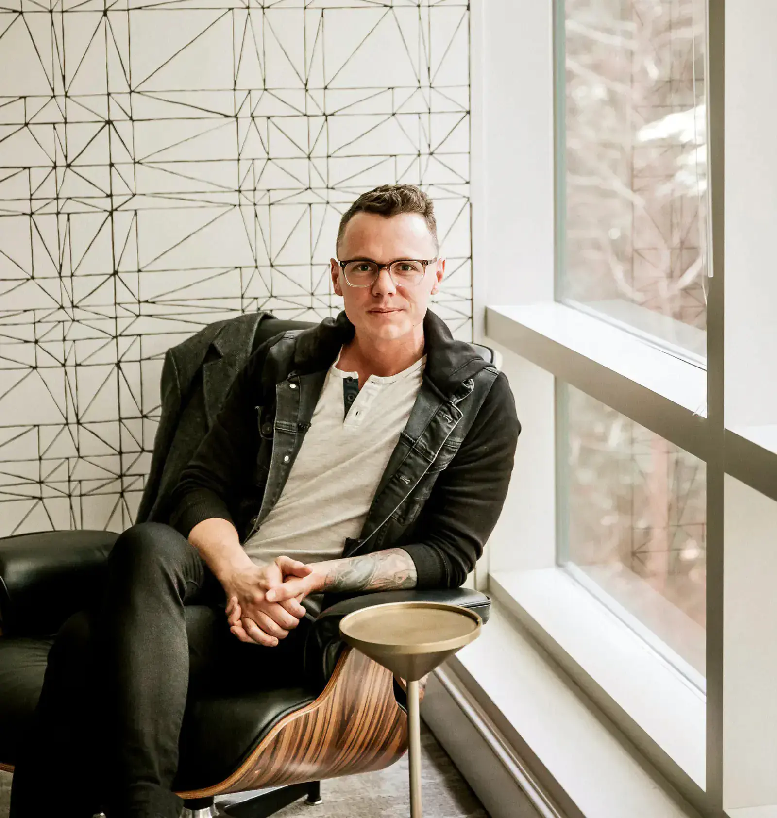 Robbie Poe seated beside a window