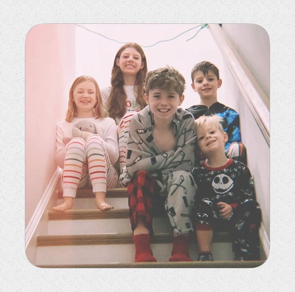 Robbie and Amanda's five children sitting together on a staircase