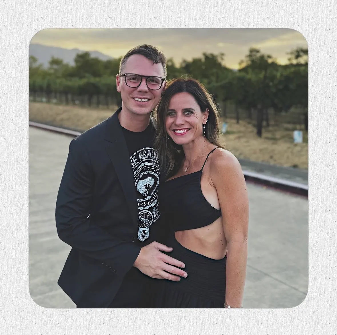 Robbie and Amanda Poe standing together in a vineyard
